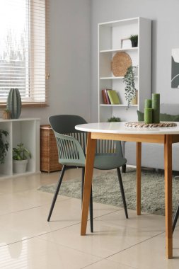 Yumuşak kanepeli şık bir oturma odası, masa ve raf ünitesi, yakın çekim.