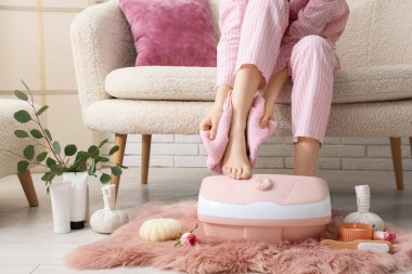 Masaj banyosu, spa malzemeleri ve okaliptüs dalları olan bir kadın.