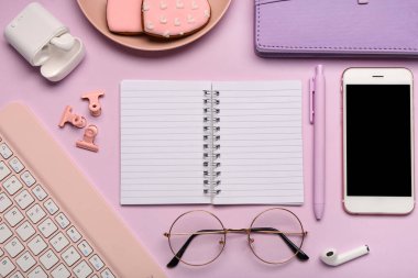 Leylak arka planında defter, gözlük ve klavye olan kompozisyon. Üst görünüm