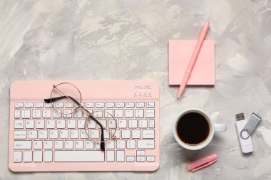 Bilgisayar klavyesi, not defteri, kahve fincanı ve grunge arkaplanda bardaklar