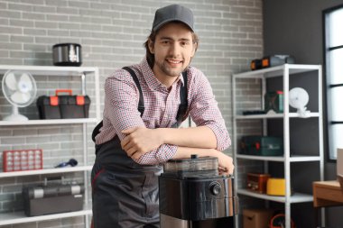 Atölyede kahve makinesi olan bir erkek tamirci.