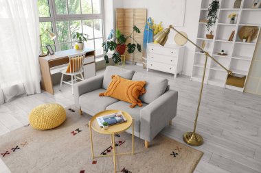 Oturma odasının içinde kanepe, işyeri ve sörf tahtası var.