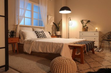 Modern yatak odasının içinde parlayan lambalar olan rahat bir yatak.