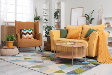 Oturma odasının içinde rahat bir kanepe, koltuk ve kahve masası.