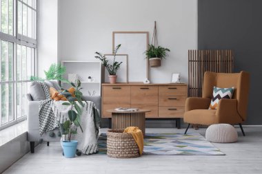 Oturma odasının içinde şık bir kanepe, rahat bir koltuk ve kahve masası var.