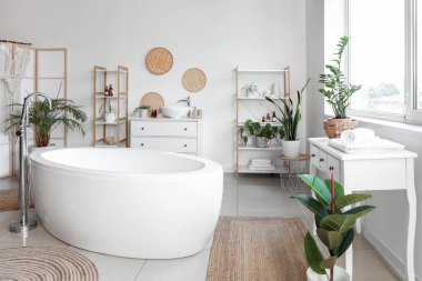 Katlanan ekran, küvet ve çiçekli hafif banyo.