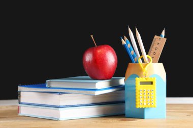 Elma, kitap ve kırtasiye masasında, karatahtanın yanında. Okul konseptine dönelim.