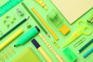Yeşil arkaplanda farklı kırtasiye malzemesi, yakın plan
