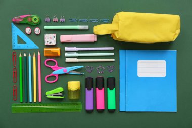 Yeşil arkaplanda farklı kırtasiye malzemesi olan kompozisyon