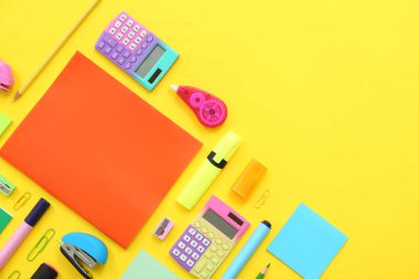 Sarı zemin üzerinde farklı kırtasiye malzemesi olan kompozisyon