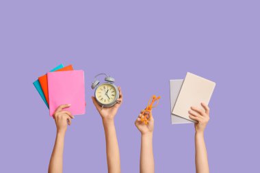 Mavi zemin üzerinde gözlüklü, defterli ve çalar saati olan bir sürü el.