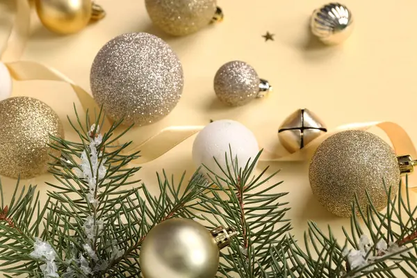 Sarı arka planda Noel baloları ve köknar dalları