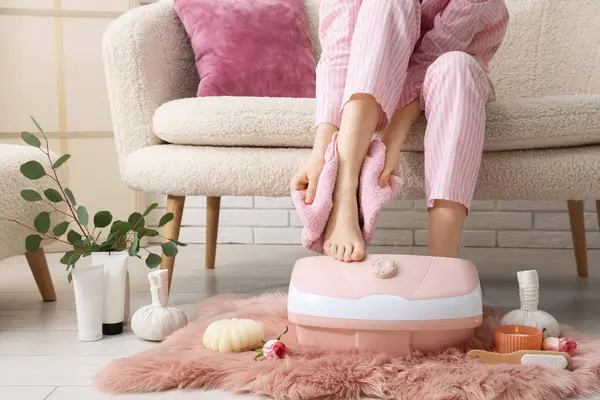 Masaj banyosu, spa malzemeleri ve okaliptüs dalları olan bir kadın.