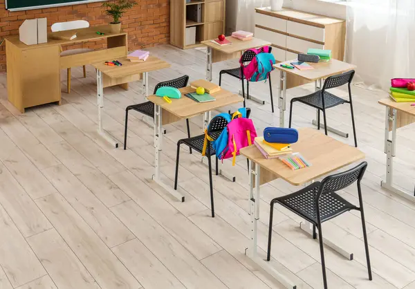 Sıraları ve sırt çantaları olan sınıfın içi.