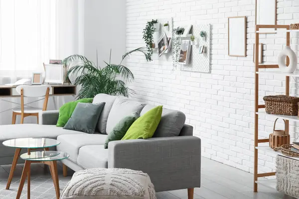 Gri kanepeli oturma odası, işyeri, raf ünitesi ve tahta tahtasıyla.