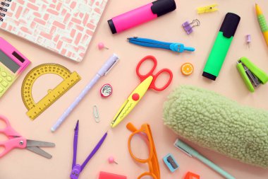 Okul malzemeleri, makas, keçeli kalem ve bej arka planda. Yakın çekim.