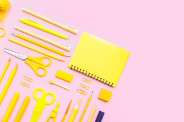 Okul malzemeleri, pembe arka planda defter, makas ve silgi. Üst görünüm