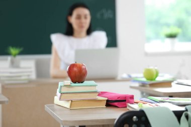 Sınıfta masa başında kitap olan elma, yakın plan.