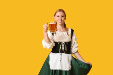 Güzel mutlu Ekim Festivali garsonu. Sarı arka planda bir kupa birayla.