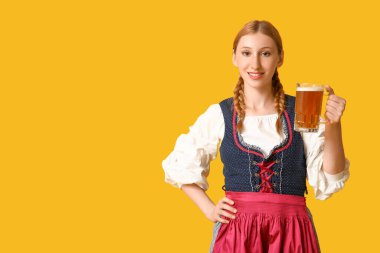 Güzel mutlu Ekim Festivali garsonu. Sarı arka planda bir kupa birayla.