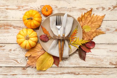 Taze balkabaklarıyla ve beyaz ahşap arka planda sonbahar yapraklarıyla güzel bir masa.