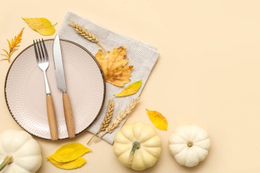 Taze balkabakları, buğday ve bej arka planda sonbahar yapraklarıyla güzel bir masa.