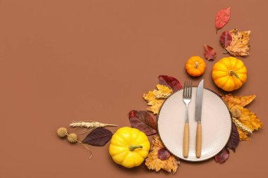 Kahverengi arka planda taze balkabağı, buğday ve sonbahar yapraklarıyla güzel bir masa.