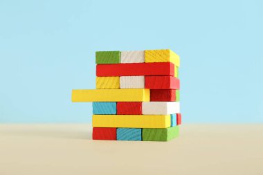 Mavi duvarın yanındaki masada renkli bloklardan bir kule var. Mantık kavramı