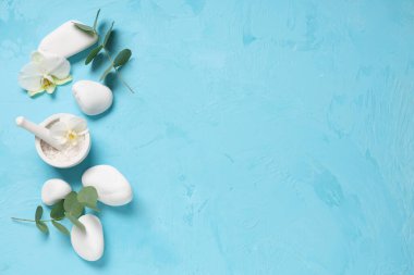 Renkli arka planda deniz tuzu, spa taşı ve okaliptüs dalları içeren kompozisyon