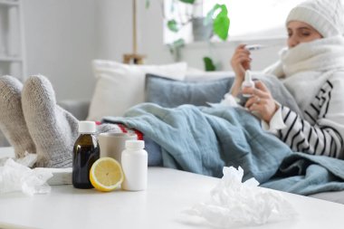 Limonlu ve hasta kadının ayaklarının olduğu farklı grip ilaçları.