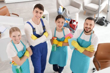 Ofisinde temizlik malzemesi olan bir grup hademe.