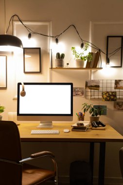 Geceleri ofiste masasında kulaklık olan boş bilgisayar monitörü.