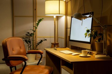 Çalışma odası, katlanan ekran ve parlayan lambalar olan karanlık ofisin içinde.