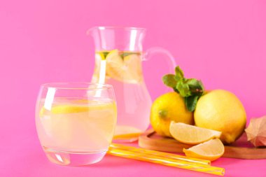 Bir bardak taze limonata ve pembe arka planda nane şekeri.