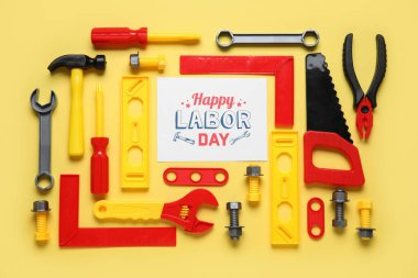 Oyuncak inşaat aletleri ve sarı zemin üzerinde 