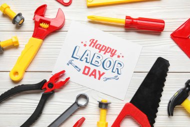 Oyuncak inşaat aletleri ve beyaz ahşap zemin üzerinde 