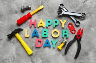 Oyuncak inşaat aletleri ve kelimeler gri grunge arka planda mutlu LABOR Günü. İşçi Bayramı kutlamaları