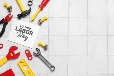 Oyuncak inşaat araçları ve beyaz kaplamalı arka planda Mutlu Günler yazılı tebrik kartı. İşçi Bayramı kutlamaları