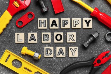 Oyuncak inşaat aletleri ve kelimeler gri grunge arka planda mutlu LABOR Günü. İşçi Bayramı kutlamaları