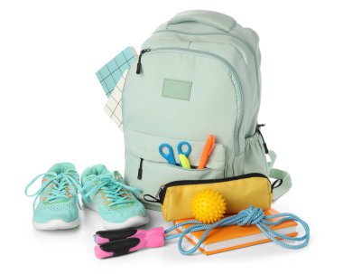 Beyaz arka planda izole edilmiş sırt çantası, okul malzemeleri ve spor ekipmanları.