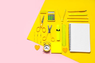 Alarm saati, hesap makinesi ve renk arkaplan üzerindeki farklı okul kırtasiyesi bileşimi