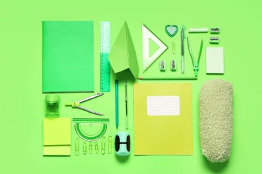 Kağıt uçak ve yeşil arka planda farklı okul kağıtları ile kompozisyon