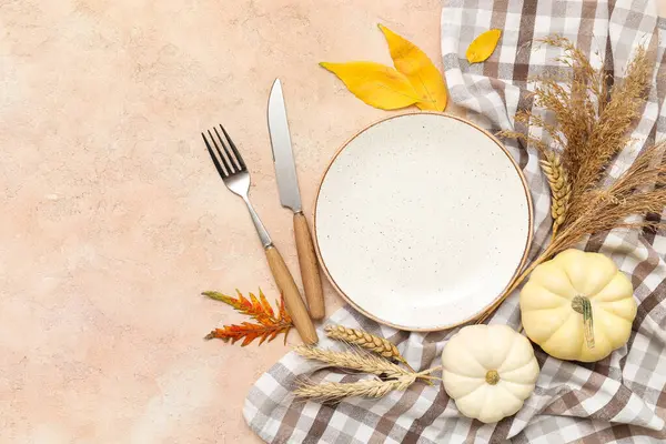 Taze balkabakları, buğday ve bej arka planda sonbahar yapraklarıyla güzel bir masa.