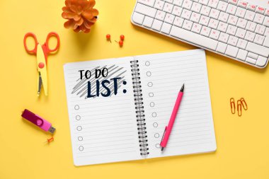 Boş yapılacaklar listesi, PC klavyesi ve sarı arkaplanda kırtasiye malzemesi olan defter