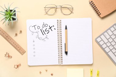 Boş yapılacaklar listesi ve bej arkaplan üzerine kırtasiye içeren not defteri