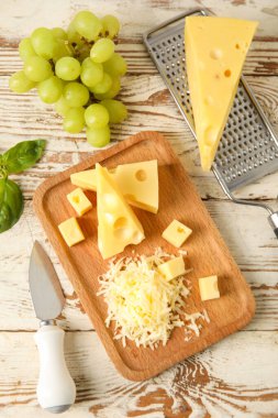 Lezzetli İsviçre peyniri ve hafif ahşap arka planda üzümlü tahta.