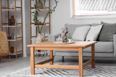 Kanepesi, masası ve çiçekleri olan bir oturma odası.