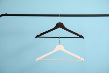 Ahşap elbiseli raflar mavi arka planda asılı.