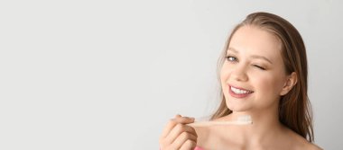 Dişlerini hafif arka planda fırçalayan mutlu kadın mesaj için yer açıyor.