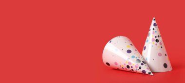 Kırmızı arkaplanda parti şapkaları ve metin için boşluk